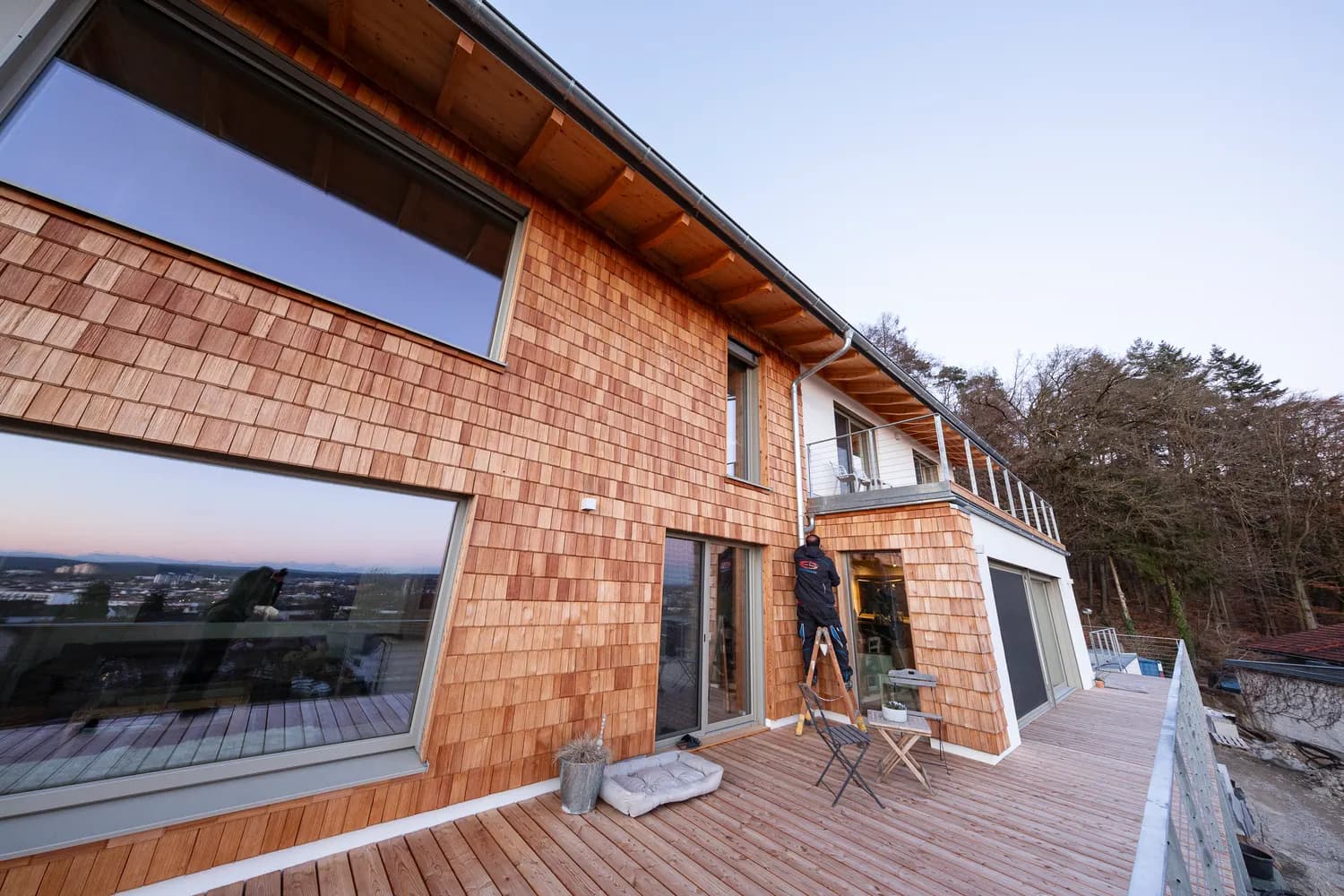 Dachterrasse eines modernen Neubaus mit Holzschindel-Fassade